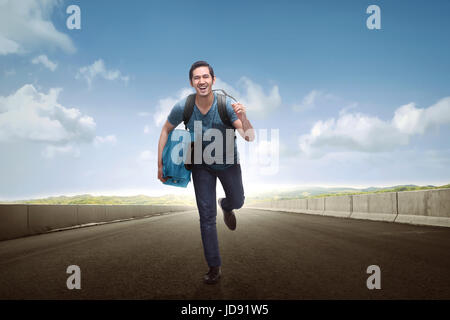 Happy asian man touristique transport des bagages le long de la rue Banque D'Images