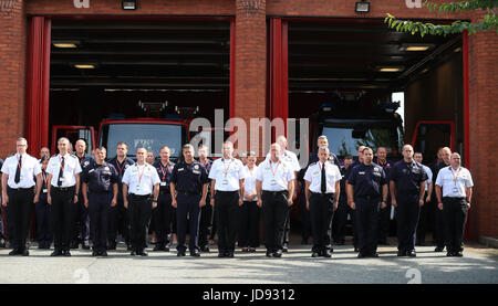 Les pompiers et le personnel à observer une minute de silence à la Manchester Community Fire Station, à la mémoire de ceux qui sont morts dans l'incendie de la tour de Grenfell, dans l'ouest de Londres la semaine dernière. Banque D'Images