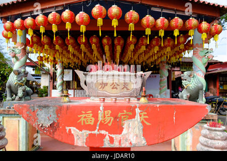 Lanternes rouges, censurer et d'encens sur l'autel d'un temple à Chew Jetty, l'un des six clans chinois jetées de Penang, Malaisie, Pulau Pinang. Banque D'Images