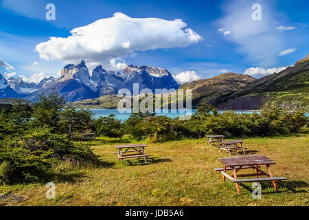 Tables de pique-nique en bois sur l'herbe sur le terrain de camping près de l'étonnant Cuernos del Paine, en Patagonie, dans le sud du Chili Banque D'Images