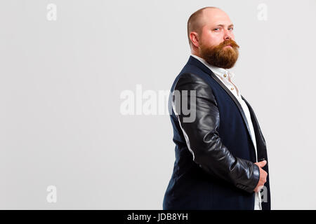 L'homme brutal avec barbe se tient sur le côté, à l'arrière-plan gris vide Banque D'Images