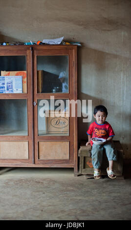 PAKSE, Laos, le 14 août : un petit garçon assis Laos manger dans la chambre de Pakse, Laos le 14 août 2010 Banque D'Images