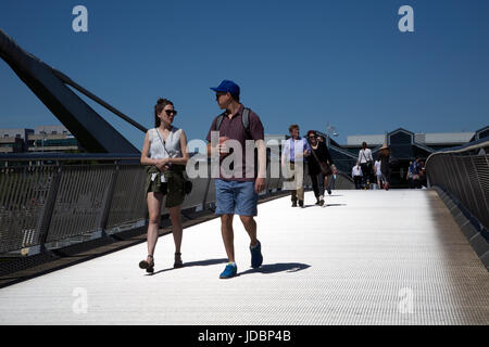 Les touristes à pied par un pont à Dublin Docklands, l'Irlande. Banque D'Images