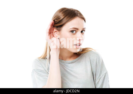 Portrait d'une jeune fille curieuse essaie d'écouter les rumeurs isolées sur fond blanc Banque D'Images