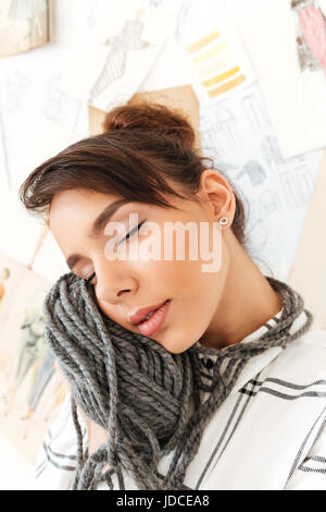 Close up portrait of a lovely girl holding la laine à tricoter près de son visage en studio Banque D'Images