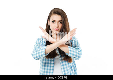 Jolie jeune fille brune traverser ses bras pour montrer aucun geste isolé sur fond blanc Banque D'Images