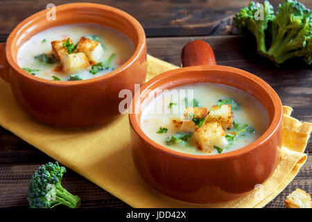 Les légumes et le fromage cheddar soupe crème de brocoli avec croûtons et sur fond de bois avec copie espace - maison bio végétarienne saine vegan Banque D'Images