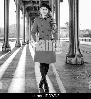 Brillante dans Paris. Portrait de jeune femme en trench-coat rouge sur le Pont de Bir-Hakeim pont de Paris Banque D'Images