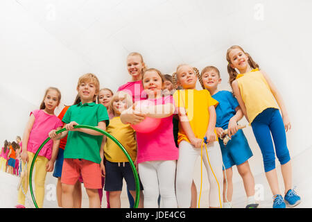 Portrait d'enfants heureux dans les vêtements de sport et entraîneur de gymnastique féminine, tenue de sport, de l'article ensemble dans une salle de sport Banque D'Images