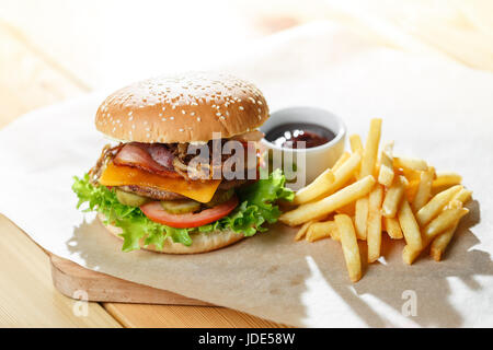 Big tasty burger et des frites sur la table en bois Banque D'Images