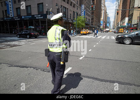 New York City cop diriger la circulation à l'intersection achalandée USA Banque D'Images