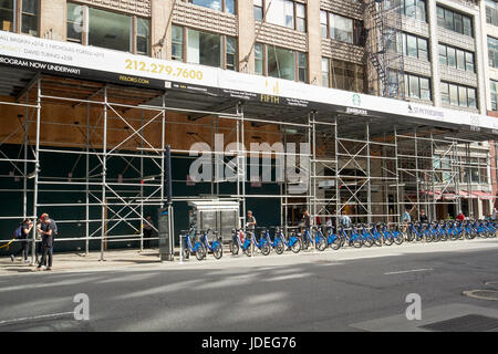 Un échafaudage sur un trottoir et de location de vélo station New York USA Banque D'Images