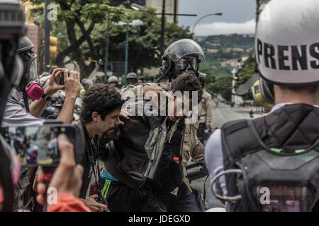 Les agents de police à l'arrestation d'un jeunes pendant les manifestations anti-gouvernementales à Caracas, Venezuela, le lundi 19 juin, 2017. Près de 70 personnes sont mortes, des centaines d'autres Banque D'Images