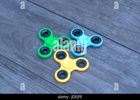 Trois fidget part spinner le jouet sur un fond de bois. Banque D'Images