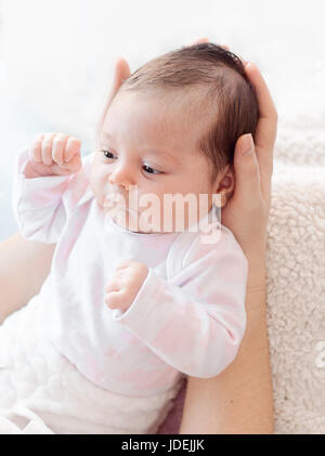 Mère doucement hands holding baby . Dodu et beau nouveau-né regarde sa mère. doux. Banque D'Images