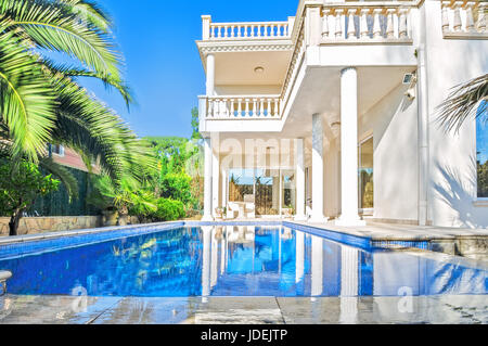 White house de luxe avec piscine. Villa de luxe de style classique avec des colonnes. Jardin avec piscine dans maison de maître. Banque D'Images