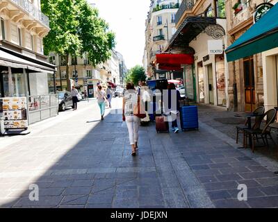 Couple walking, tirant deux grandes valises sur chaque journée chaude à Paris, France Banque D'Images