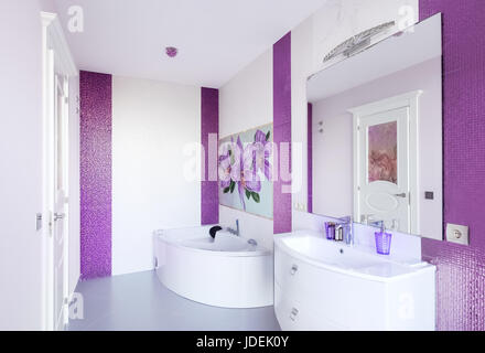 Salle de bains moderne avec un intérieur panneau de mosaïque. Baignoire blanc contre un mur blanc et violet Banque D'Images