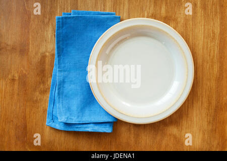 Vue de dessus d'une plaque de couleur crème vide et serviette bleu Banque D'Images