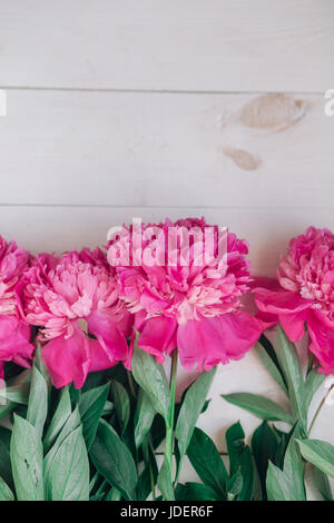 Floral frame avec pivoines rose sur fond de bois blanc Banque D'Images