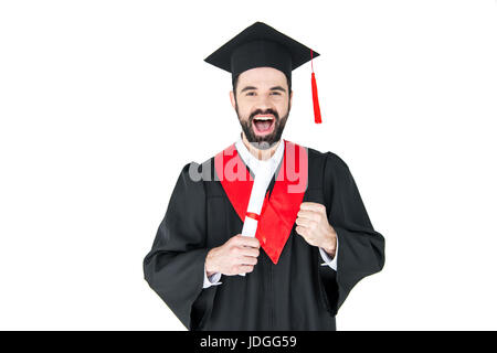 Jeune homme excité in graduation hat holding diploma et triomphant sur blanc Banque D'Images