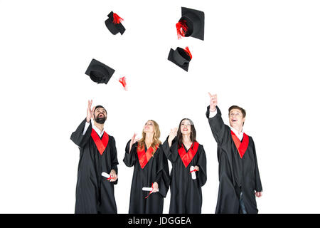 Professionnels de jeunes étudiants diplômés de jeter leur diplôme caps isolated on white Banque D'Images