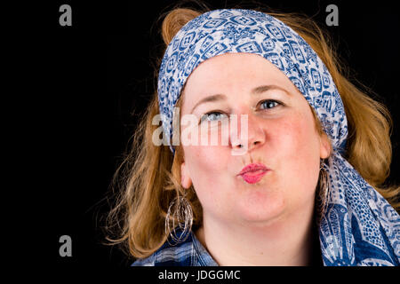 Portrait d'une jolie lumière européenne surpondérés red haired femme l'envoi de baisers, portant chemise bûcheron bleu et foulard bleu comme la coiffure, les chefs Banque D'Images