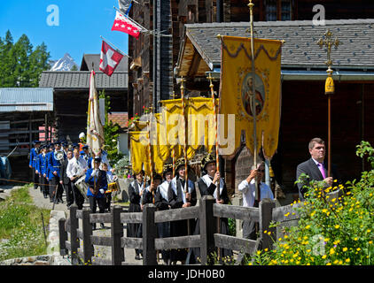 Les femmes en costume portant des bannières religieuses à la procession du Corpus Christi, Blatten, Lötschental, Valais, Suisse Banque D'Images