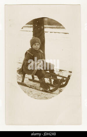 Début des années 1900 Carte postale de garçon sur un traîneau, peut-être l'allemand, vers 1930 Banque D'Images