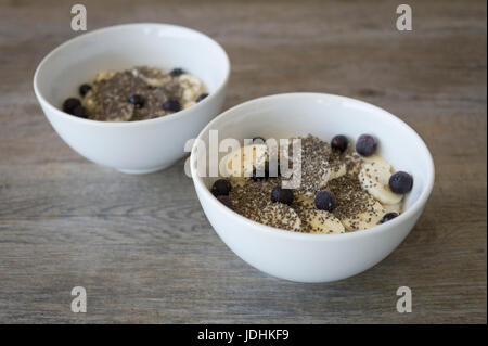 Deux bols de porridge à la banane, les graines de chia et bleuets Banque D'Images