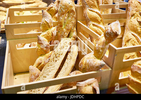 Baguettes de pain blanc frais dans des caisses en bois sur le comptoir de l'épicerie Banque D'Images