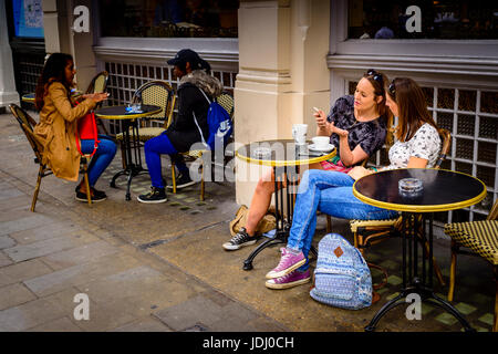 Les jeunes femmes à se parler à la terrasse d'un cafe, London, UK Banque D'Images