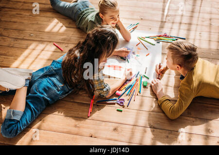 Cute kids dessin sur papier avec des crayons on Banque D'Images