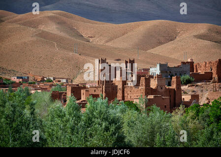 Village Aci Ouglif avec argile casbahs dans la vallée du Dadès avec les montagnes de haut Atlas derrière, Maroc, Afrique Banque D'Images