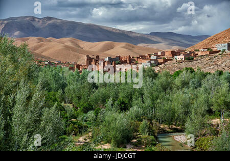 Village Aci Ouglif avec argile casbahs dans la vallée du Dadès avec les montagnes de haut Atlas derrière, Maroc, Afrique Banque D'Images