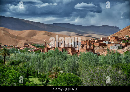 Village Aci Ouglif avec argile casbahs dans la vallée du Dadès avec les montagnes de haut Atlas derrière, Maroc, Afrique Banque D'Images