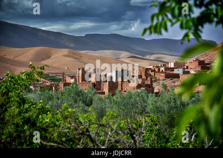 Village Aci Ouglif avec argile casbahs dans la vallée du Dadès avec les montagnes de haut Atlas derrière, Maroc, Afrique Banque D'Images