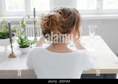 Woman sitting at table Banque D'Images