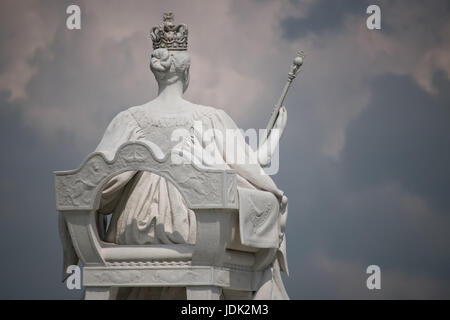 Juste à l'extérieur de Kensington Palace se dresse une statue de Victoria à la puissante sur les jardins où elle a grandi. Banque D'Images