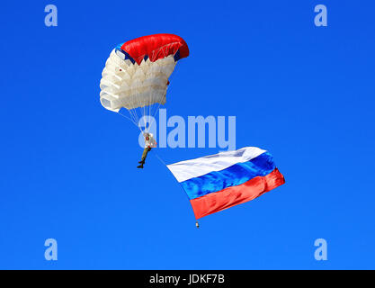 Parachutiste descend en parachute avec bannière de russa. temps juste avant l'atterrissage Banque D'Images