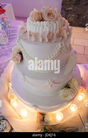 Gâteau de mariage avec des roses rose et candls Banque D'Images