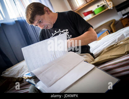 Nieder-Roden, Allemagne. 29 mai, 2017. Frank-Josef Ackerman feuillette les nombreux documents de la part de médecins et des autorités qui se sont accumulés au cours des dernières années dans sa maison de Nieder-Roden, Allemagne, 29 mai 2017. Le patient de la douleur est l'un des rares autorisé à cultiver du cannabis, même si seulement pour la consommation personnelle. La Cour constitutionnelle fédérale a décidé que le cannabis cultivé par l'auto-thérapie pour malades dans leurs propres maisons ne doivent pas être confisqués par la police tant qu'ils remplissent certaines conditions préalables. Photo : Frank Rumpenhorst/dpa/Alamy Live News Banque D'Images