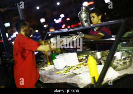 (170620) -- LE CAIRE, Juin 20, 2017 (Xinhua) -- les jeunes hommes égyptiens préparer la nourriture à un Bean 'Panier', un petit stand de rue qui sert le traditionnel repas pré-jeûne, connu comme Suhur, pendant le mois du Ramadan, sur le trottoir à Héliopolis dans la banlieue du Caire, Égypte, le 19 juin 2017. Le bean unique charrettes sont exploités par un groupe de jeunes très instruits égyptiens, qui espère que d'utiliser une partie des recettes pour des activités de bienfaisance. "L'objectif principal de ce projet de départ l'année dernière est la charité,' Hussein Hamza, 30 ans, cofondateur du projet, a déclaré à Xinhua. Le groupe de travail seulement duri Banque D'Images