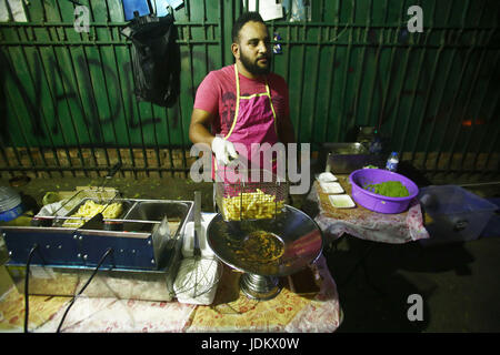 (170620) -- LE CAIRE, Juin 20, 2017 (Xinhua) -- Un jeune homme égyptien prépare la nourriture à un Bean 'Panier', un petit stand de rue qui sert le traditionnel repas pré-jeûne, connu comme Suhur, pendant le mois du Ramadan, sur le trottoir à Héliopolis dans la banlieue du Caire, Égypte, le 19 juin 2017. Le bean unique charrettes sont exploités par un groupe de jeunes très instruits égyptiens, qui espère que d'utiliser une partie des recettes pour des activités de bienfaisance. "L'objectif principal de ce projet de départ l'année dernière est la charité,' Hussein Hamza, 30 ans, cofondateur du projet, a déclaré à Xinhua. Le groupe de travail uniquement Banque D'Images