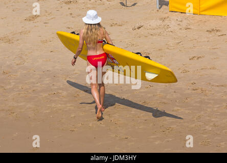 Bournemouth, Dorset, UK. 21 Juin, 2017. Météo France : un autre jour ensoleillé chaud à plages de Bournemouth à la hausse des températures pour continuer la canicule et les visiteurs de la station de tête de parfaire votre bronzage. L'ANR femelle Lifeguard wearing bikini et hat exerçant son traîneau sur la vie de surf la plage de Bournemouth. Credit : Carolyn Jenkins/Alamy Live News Banque D'Images