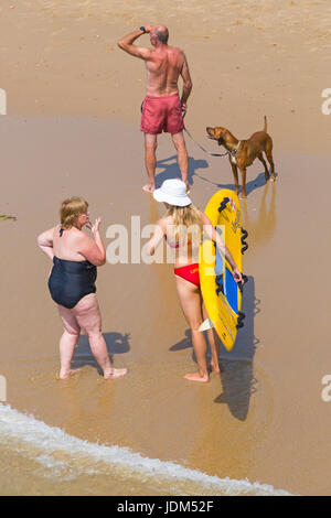 Bournemouth, Dorset, UK. 21 Juin, 2017. Météo France : un autre jour ensoleillé chaud à plages de Bournemouth à la hausse des températures pour continuer la canicule et les visiteurs de la station de tête de parfaire votre bronzage. L'ANR femelle Lifeguard wearing bikini et hat exerçant son traîneau de la vie sur la plage de Bournemouth surf parler aux visiteurs. Credit : Carolyn Jenkins/Alamy Live News Banque D'Images