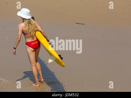 Bournemouth, Dorset, UK. 21 Juin, 2017. Météo France : un autre jour ensoleillé chaud à plages de Bournemouth à la hausse des températures pour continuer la canicule et les visiteurs de la station de tête de parfaire votre bronzage. L'ANR femelle Lifeguard wearing bikini et hat exerçant son traîneau sur la vie de surf la plage de Bournemouth. Credit : Carolyn Jenkins/Alamy Live News Banque D'Images