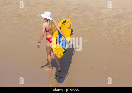 Bournemouth, Dorset, UK. 21 Juin, 2017. Météo France : un autre jour ensoleillé chaud à plages de Bournemouth à la hausse des températures pour continuer la canicule et les visiteurs de la station de tête de parfaire votre bronzage. L'ANR femelle Lifeguard wearing bikini et hat exerçant son traîneau sur la vie de surf la plage de Bournemouth. Credit : Carolyn Jenkins/Alamy Live News Banque D'Images