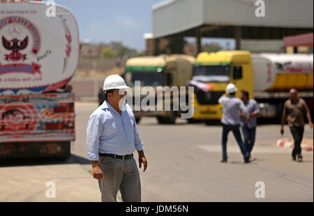 21 juin 2017 - Nusseirat, dans la bande de Gaza, territoire palestinien - Palestiniens à pied comme les camions transportant du carburant égyptien arrivent à Gaza's power plant à Nusseirat, dans le centre de la bande de Gaza après l'entrée dans le sud de la bande de Gaza de l'Egypte à travers le passage de Rafah le 21 juin 2017. L'Égypte a commencé à livrer un million de litres de carburant à Gaza, un responsable palestinien a déclaré, dans une tentative pour alléger l'enclave palestinienne désespérée de l'électricité. Le combustible, amené par camion à travers la frontière de Rafah entre l'Egypte et Gaza, seront acheminés vers la seule station d'alimentation -- fermé depuis avril en raison de Banque D'Images