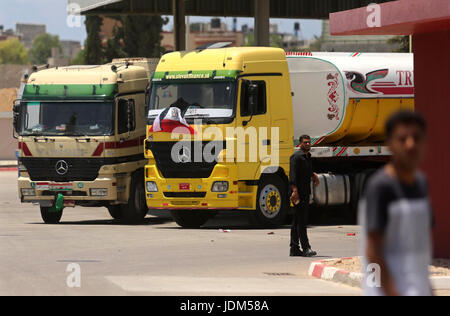 21 juin 2017 - Nusseirat, dans la bande de Gaza, territoire palestinien - Palestiniens à pied comme les camions transportant du carburant égyptien arrivent à Gaza's power plant à Nusseirat, dans le centre de la bande de Gaza après l'entrée dans le sud de la bande de Gaza de l'Egypte à travers le passage de Rafah le 21 juin 2017. L'Égypte a commencé à livrer un million de litres de carburant à Gaza, un responsable palestinien a déclaré, dans une tentative pour alléger l'enclave palestinienne désespérée de l'électricité. Le combustible, amené par camion à travers la frontière de Rafah entre l'Egypte et Gaza, seront acheminés vers la seule station d'alimentation -- fermé depuis avril en raison de Banque D'Images